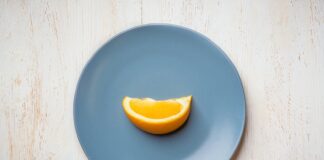 La vaisselle jetable pour un anniversaire pratique et esthétique a blue plate with a half of an orange on it