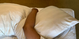 Qu’est-ce que l’asthénie sexuelle ? Too lazy to get out of bed, a man covers her face with a pillow