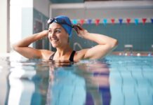 Quels sont les risques et les contre-indications de la natation ? Female Swimmer Wearing Hat And Goggles Training In Swimming Pool