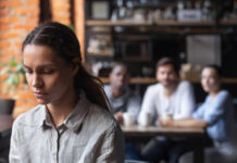 Avez-vous déjà entendu parler du syndrome de Fregoli ? Upset mixed race woman suffering from bullying, sitting alone in cafe