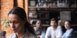 Avez-vous déjà entendu parler du syndrome de Fregoli ? Upset mixed race woman suffering from bullying, sitting alone in cafe