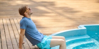 Comment savoir si ma piscine en béton a besoin de réparations ? A young man in blue swim shorts at the swimming pool