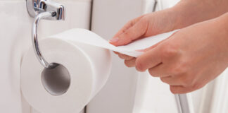 Pourquoi opter pour du papier toilette professionnel Best Hygiène ? Person's Hand Using Toilet Paper