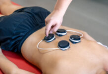 Se muscler avec l’électrostimulation : le guide complet Personne utilisant des électrodes de musculation sur les abdominaux