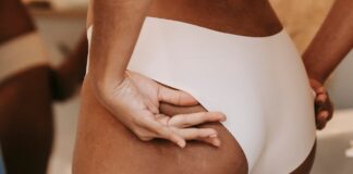 Brazilian Butt Lift : les dangers d’une chirurgie Zoom sur les fessiers et les hanches d'une femme en sous-vêtements blancs évaluant sa silhouette avant un Brazilian Butt Lift ou un lipofilling.