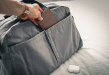 Tourisme médical : que savoir avant de partir ? Une personne prépare sa valise de voyage en y insérant son passeport avant de partir pour un séjour de tourisme médical à l'étranger.