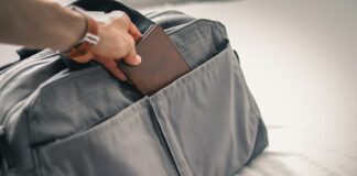 Tourisme médical : que savoir avant de partir ? Une personne prépare sa valise de voyage en y insérant son passeport avant de partir pour un séjour de tourisme médical à l'étranger.