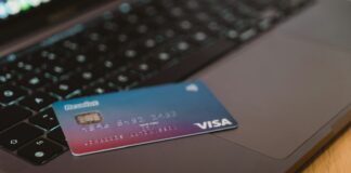 De l’or dans votre carte bancaire : ne la jetez plus ! Carte bancaire dégradé bleu et rose avec sa puce dorée (or) posée sur un clavier d'ordinateur portable ouvert.